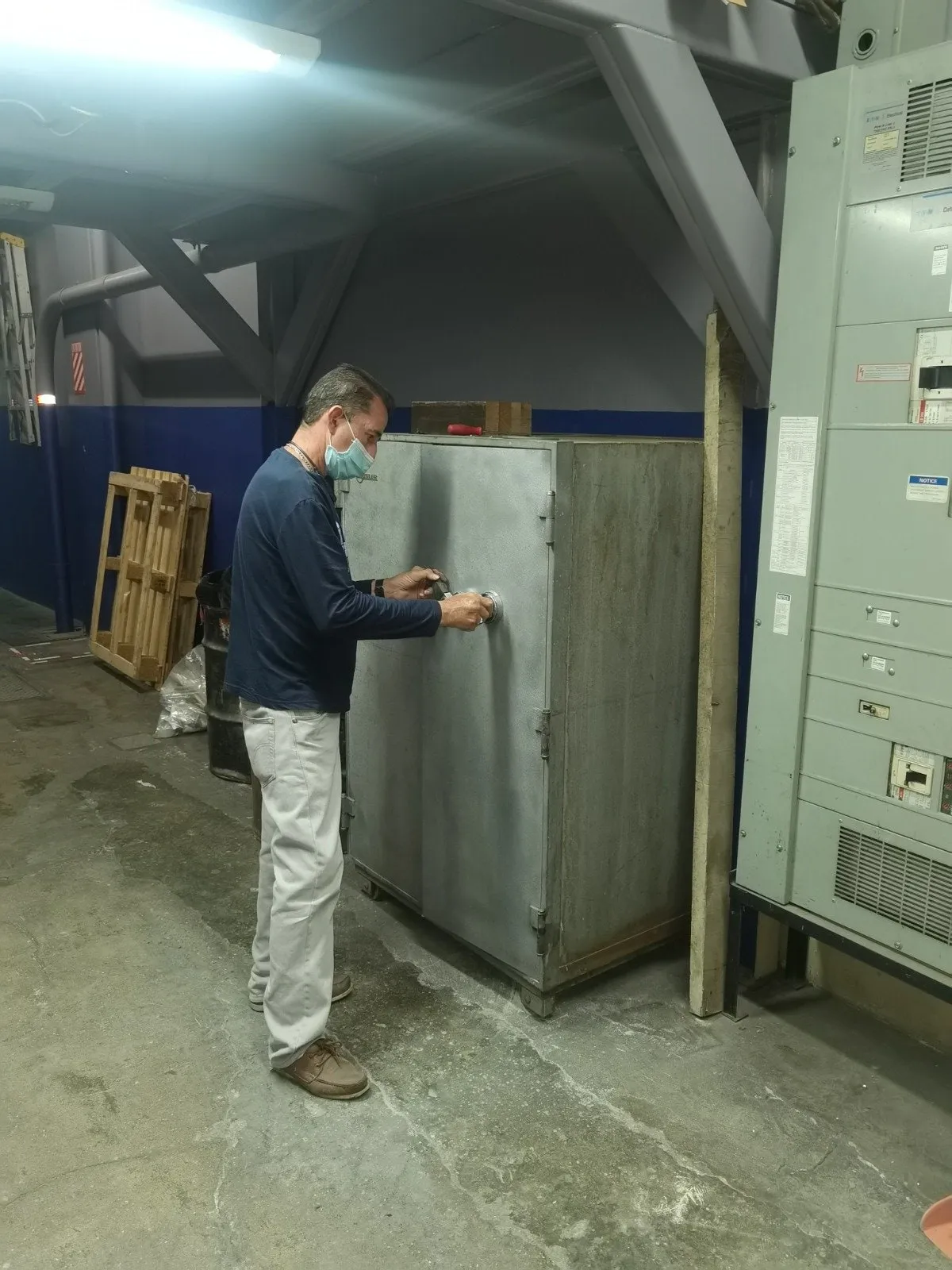 Técnico frente a una caja fuerte metálica de gran tamaño en una bodega.