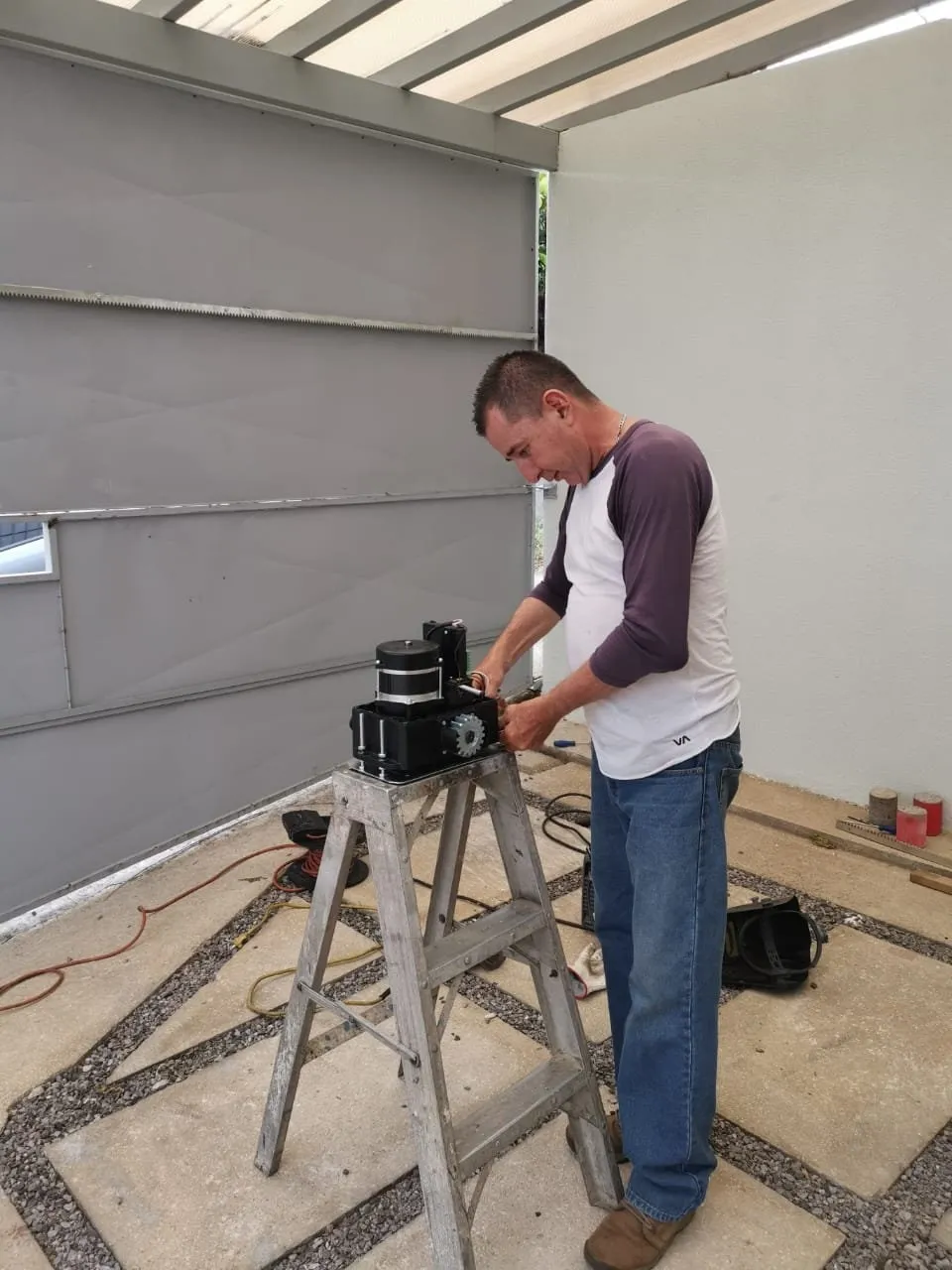 Técnico revisando un motor de portón eléctrico sobre una mesa de trabajo.